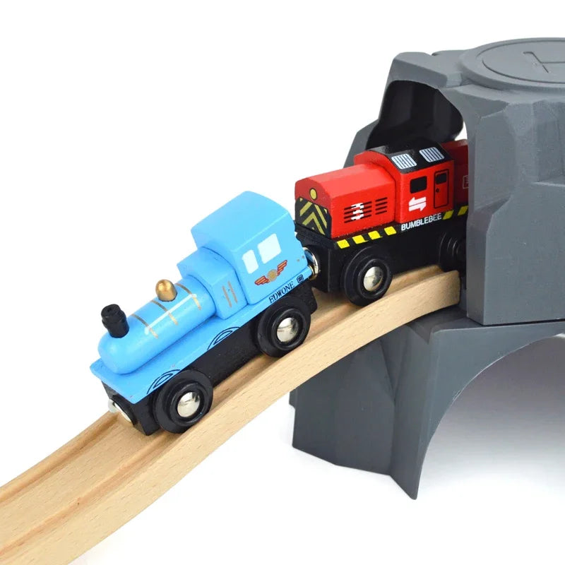 A blue train car and a red train car are placed on a wooden track within a gray magnetic train set.