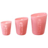 Un set de tasses à mesurer en silicone roses avec doubles échelles pour la mesure de liquides.