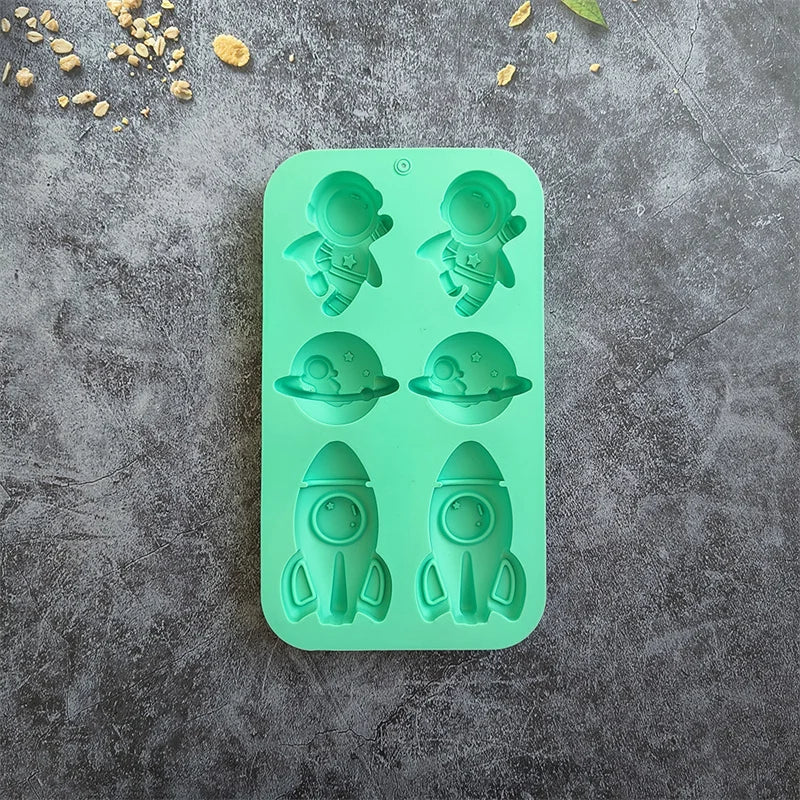 A silicone mold with six green astronaut rocket shapes for DIY crafts