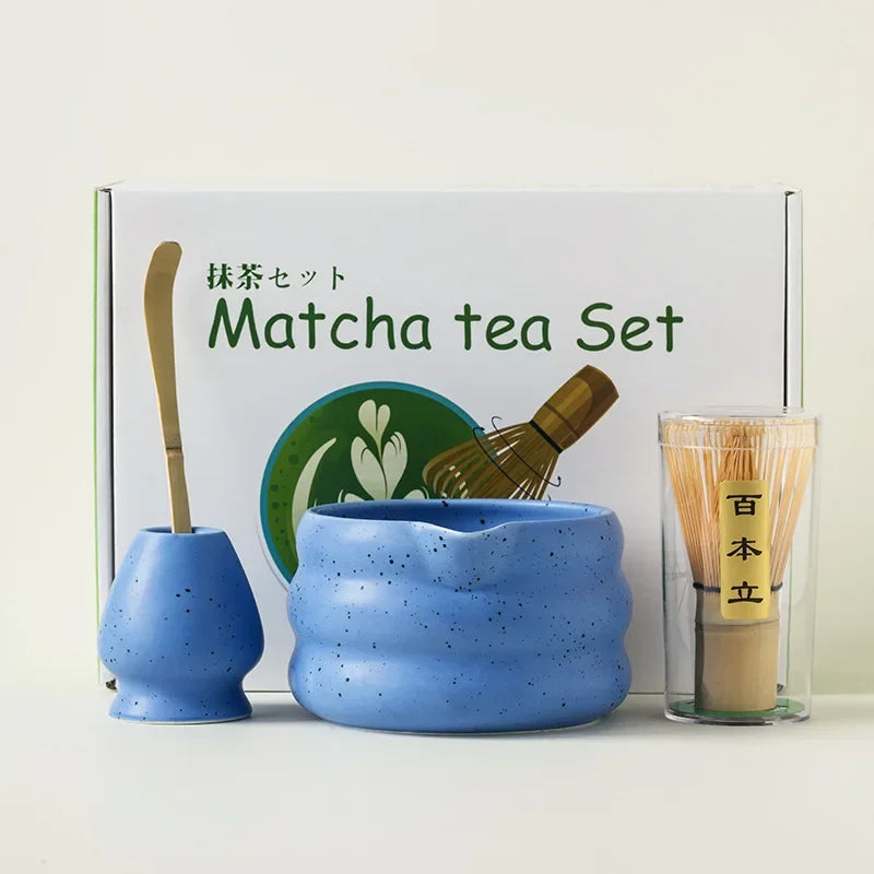 A matcha tea set featuring a blue ceramic bowl, bamboo whisk, and tea caddy displayed in a white box.