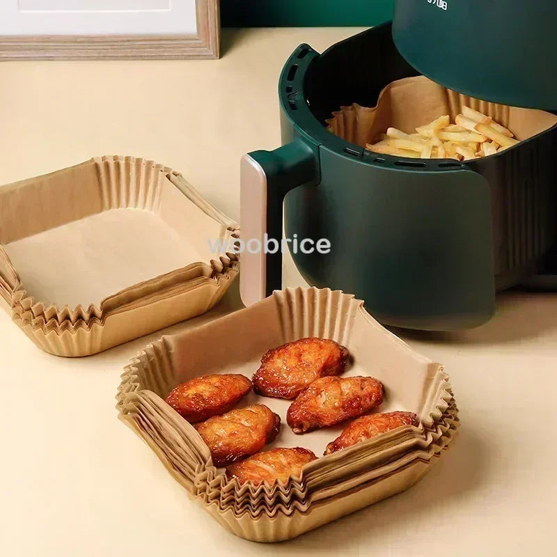 Dunkelgrüner Airfryer-Korb gefüllt mit goldbraun frittiertem Essen und mehreren Backpapier-Liner