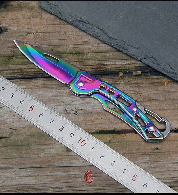 Klappmesser aus Edelstahl mit irisierendem lila und blauem Finish neben einem Lineal