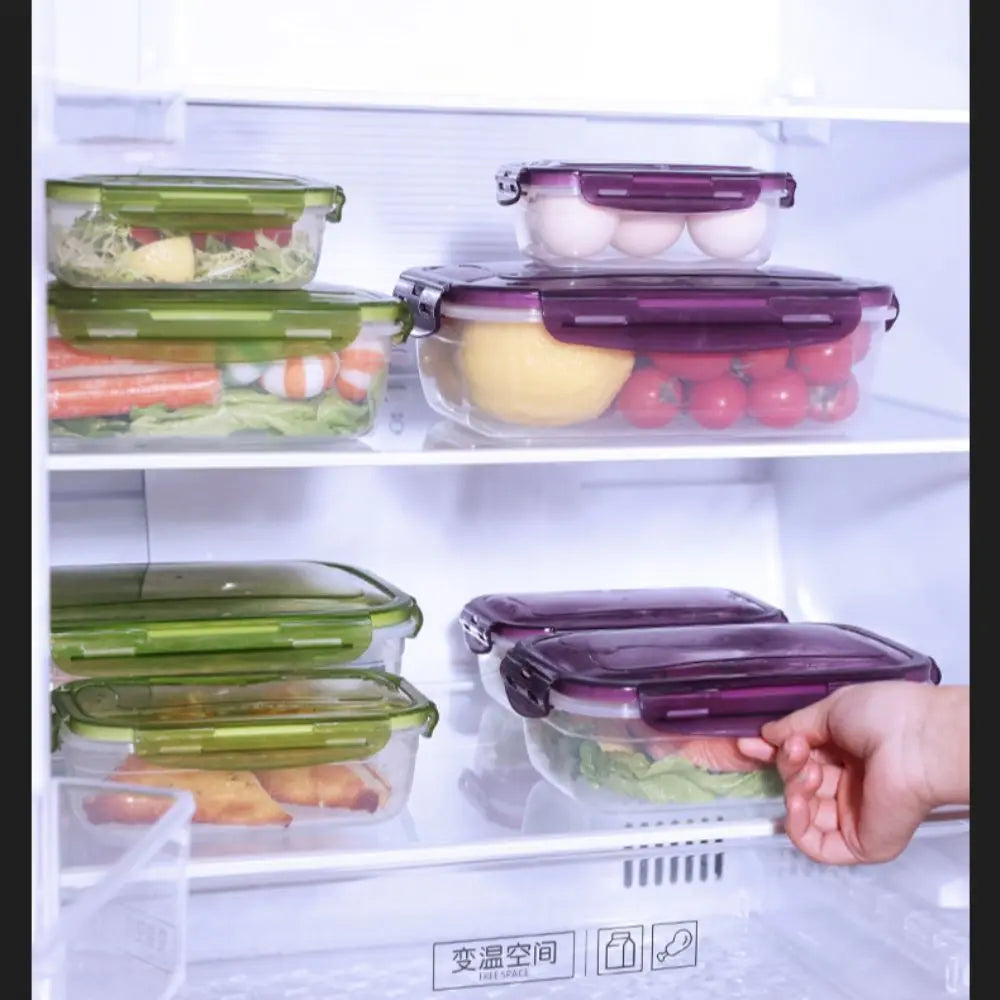 Stackable airtight refrigerator storage boxes with various colored lids and contents on glass trays