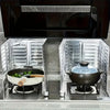 A stainless steel cooktop with two glass baffle protectors holding a black pot and a blue-tinted lid.
