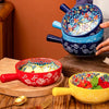 A hand-painted ceramic salad bowl with a handle is shown in various colors, including blue, red, and yellow.