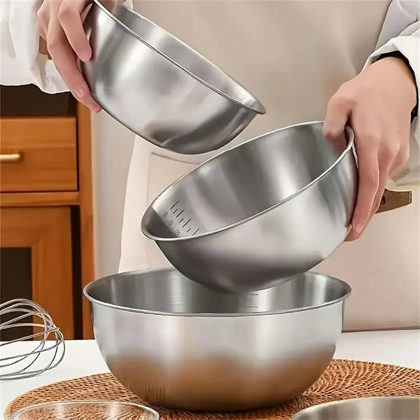 Ein Set aus drei Edelstahl-Rührschüsseln mit Messgewichten, gehalten von einer Hand.