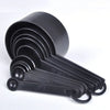 A black precision kitchen measuring tools set with multiple graduated cups and a hinged handle.