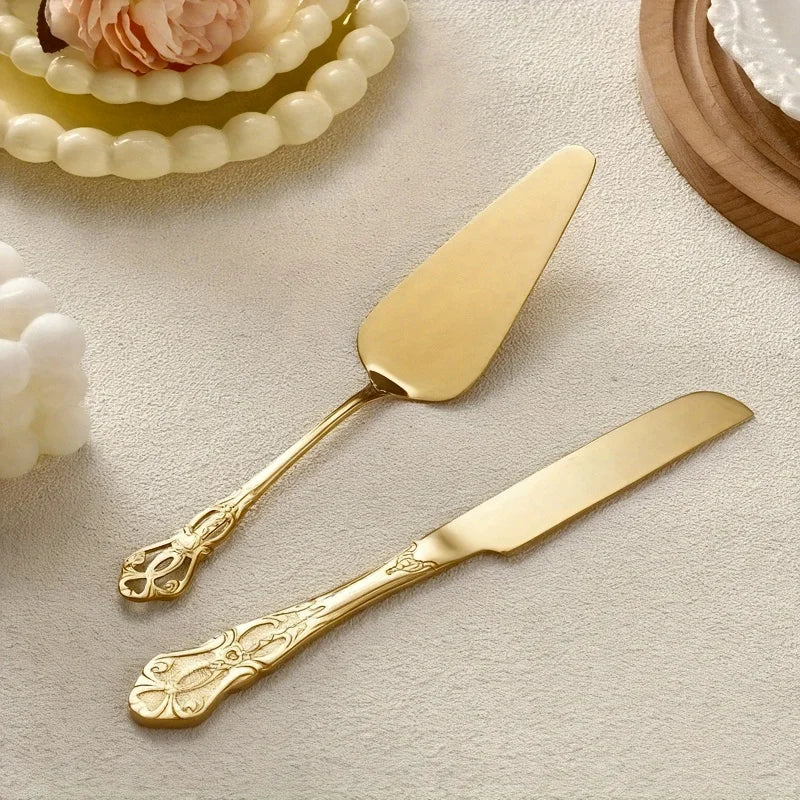 A set of elegant vintage stainless steel bread knife and cake spatula with gold accents on a light background.