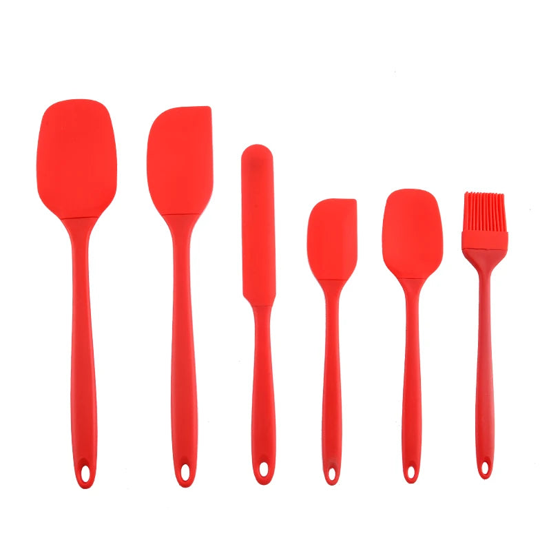 A set of six red silicone kitchen tools including spatulas and a brush for baking and food preparation.
