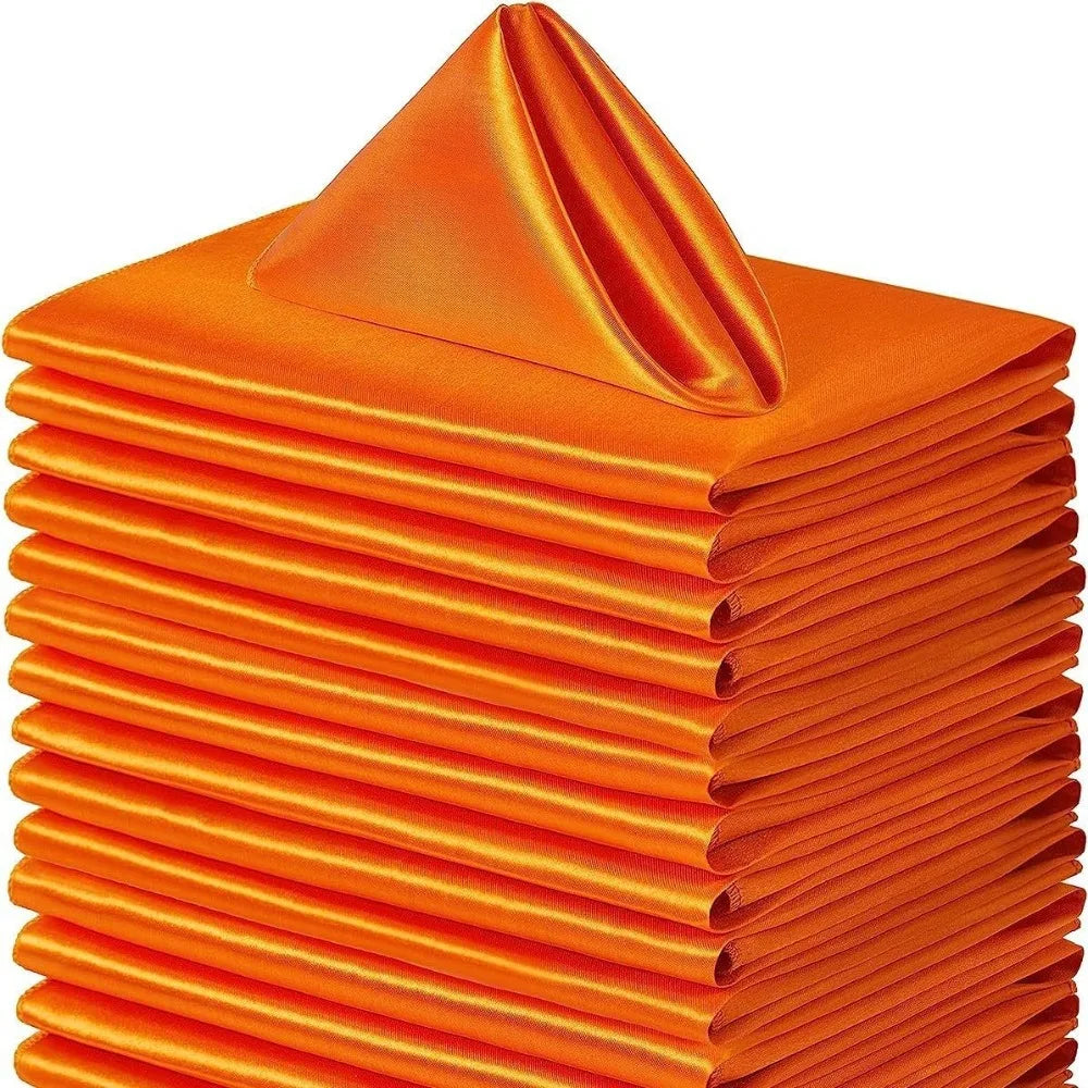 A stack of ten bright orange satin dinner napkins folded neatly.