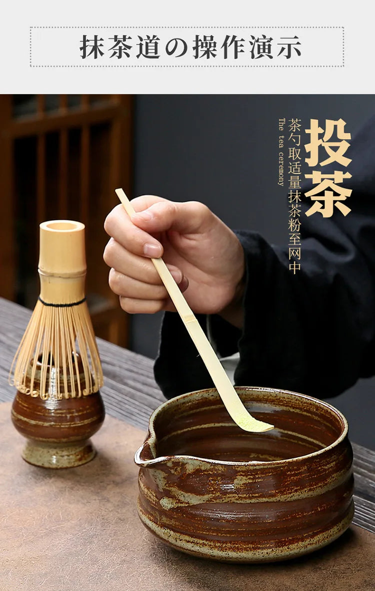 A hand is using a bamboo whisk to prepare matcha in a traditional ceramic bowl.
