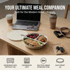 A set of stackable stainless steel divided dinner plates with lids shown on a wooden table.