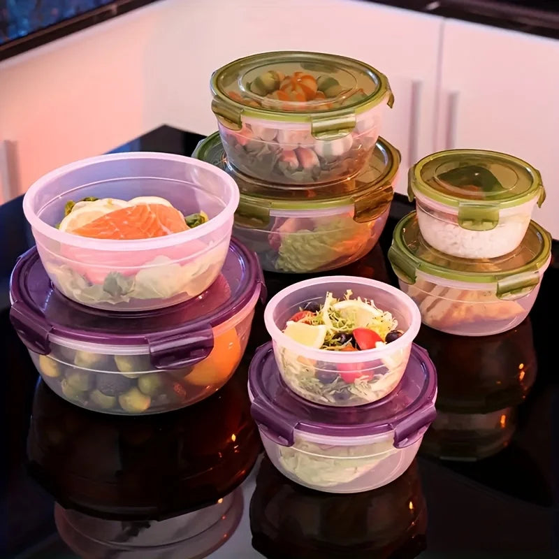 A stack of clear and colored airtight food storage containers with lids on a dark surface.
