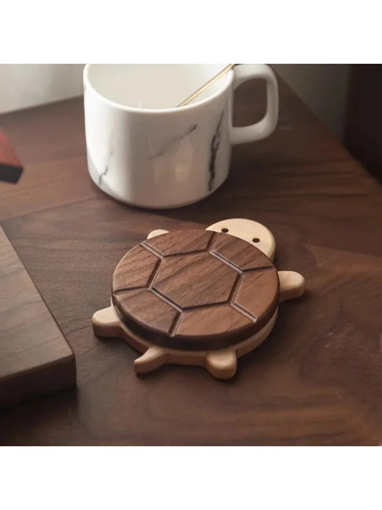 A set of solid wood turtle insulation mats and coasters resting on a dark wooden surface next to a white mug.