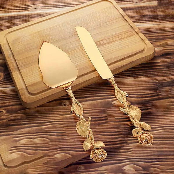 Goldbesteckset aus Metall (Messer und Schaufel) auf einem Holzbrett.