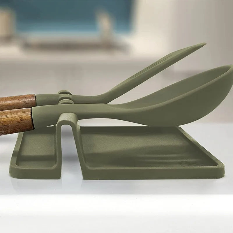 A silicone utensil drying rack organizer with a wooden handle and green silicone spoon and spatula.