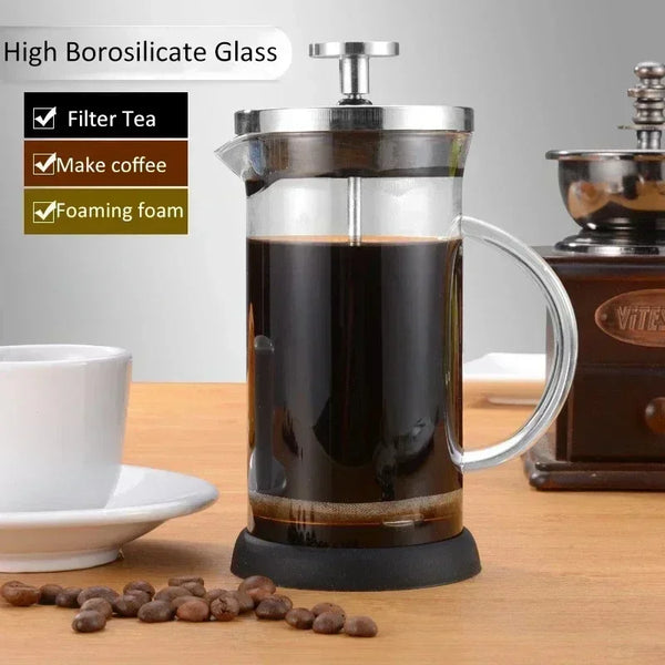Glas- und Edelstahl-Kaffeepresse mit gebrühtem Kaffee, die Filterteezubereitung und Schaum darstellen.