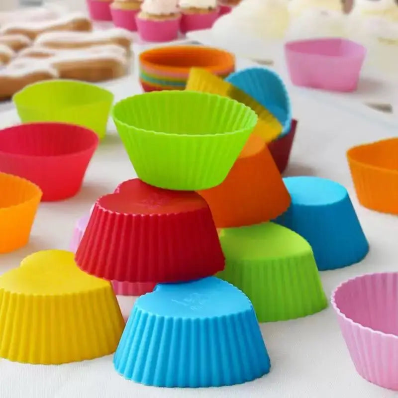 A colorful set of silicone muffin and cake baking molds in various shades of green, orange, pink, and blue.