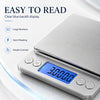 A silver digital kitchen scale with a blue backlight display showing 30000.0