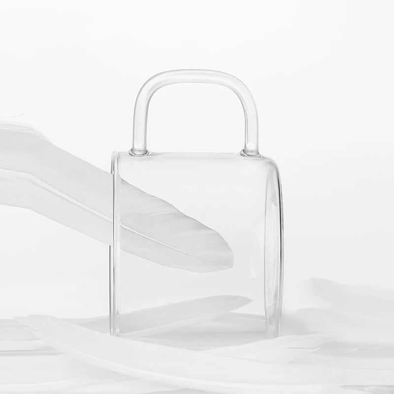 A clear borosilicate glass tea cup set with a handle is shown against a white background.