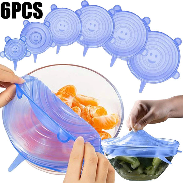 Ein Set aus sechs wiederverwendbaren Silikon-Einspeisepfannen und eine klare Glasschale mit Essen darin.
