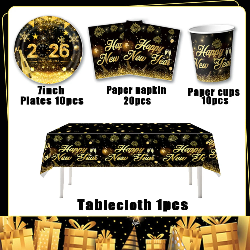 A set of gold and black disposable party tableware including plates, napkins, cups, and a tablecloth for a New Year celebrati