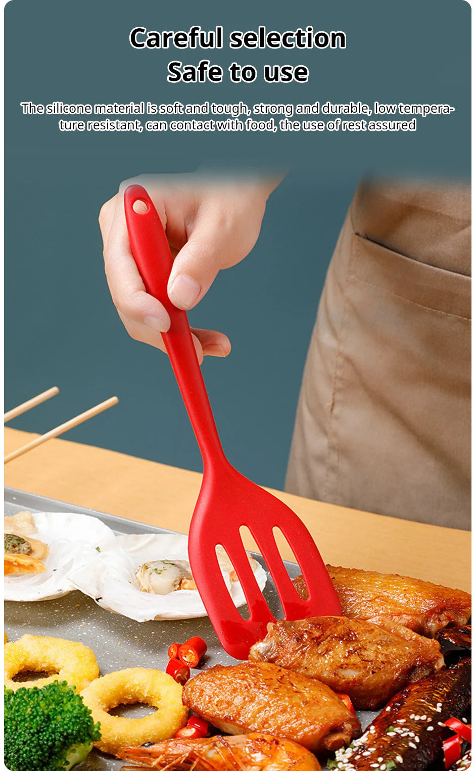 A hand holds a red silicone flat bottom frying spatula over food on a cooking surface.