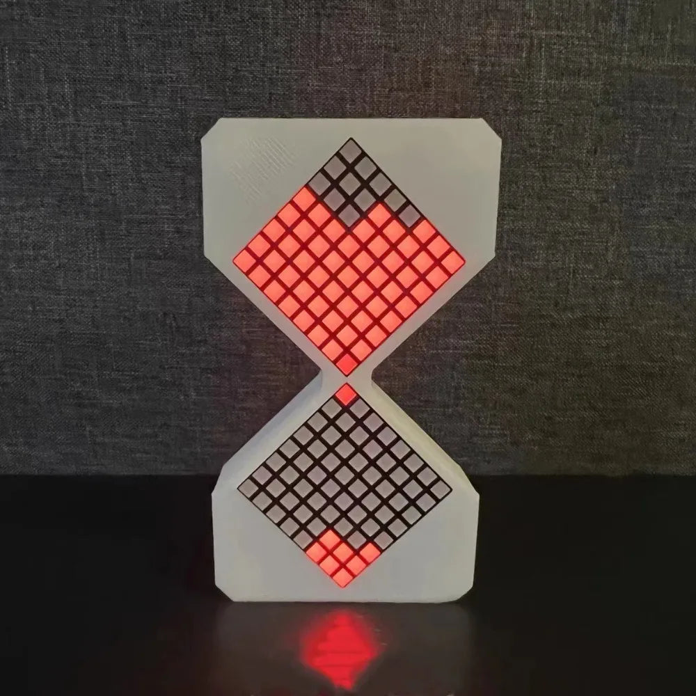 A white LED digital hourglass timer with a red and black diamond pattern, displayed on a dark surface.