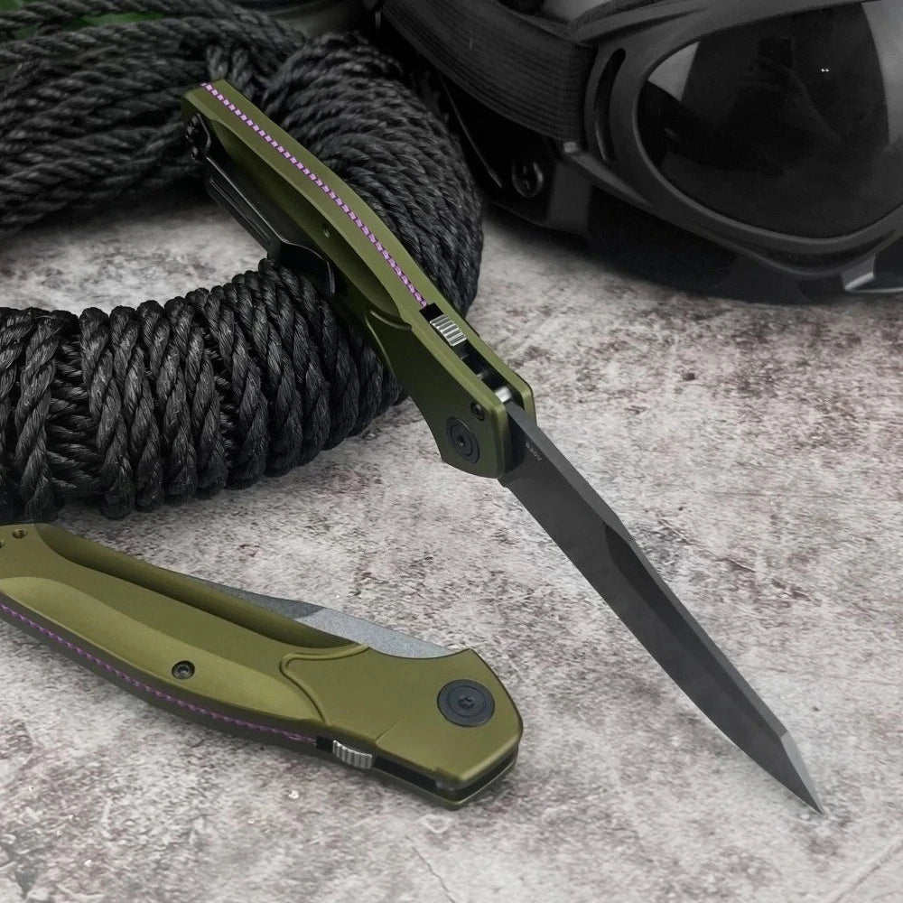 A folding pocket knife with a green handle and D2 blade is shown next to a black cord and sunglasses.