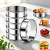 A stack of six stainless steel nonstick baking rings next to a muffin and a hamburger.
