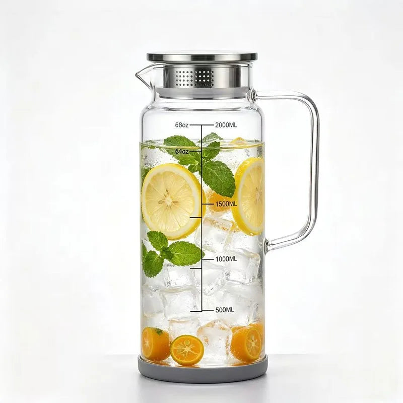 A clear glass water jug filled with ice, lemon slices, and mint leaves, featuring a metal lid and handle.