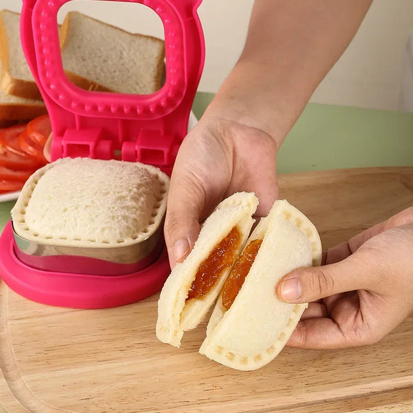 Eine Hand hält ein Sandwich, das mit einem rosa Kunststoff-Sandwich-Trenner und Edelstahlformen in der Hälfte geschnitten wur