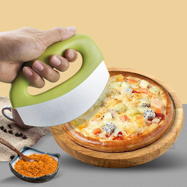Eine Hand hält einen grünen Edelstahl-Pizza-Slicer mit weißer Abdeckung über eine frisch gebackene Pizza auf einem Holzbrett.
