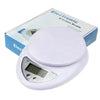A white digital kitchen scale with a flat round weighing platform and a display showing 5kg capacity.