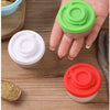 Un set de quatre mini shakers d'épices verts, blancs et rouges sur une surface en bois.