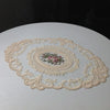 Oval embroidered lace coasters featuring floral patterns on a white surface.