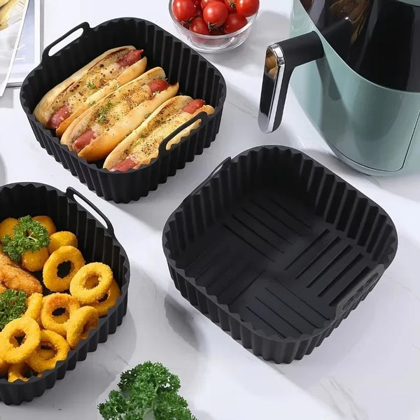 Schwarze Silikon-Airfryer-Einlagen mit geschnittenem Brot und anderen Lebensmitteln
