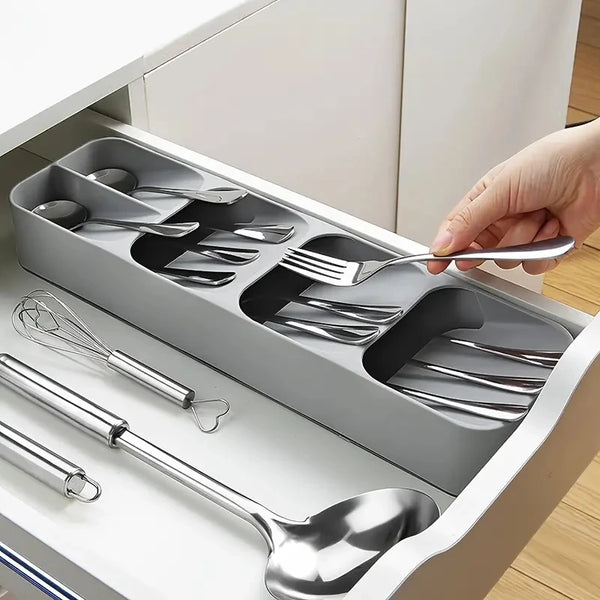 Eine Hand steckt eine Gabel in eine mitfachende Metall-Bestecktaschenorganisator-Schale.
