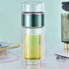 A double-layer borosilicate glass tea infuser with a clear liquid inside and a rose gold cap.