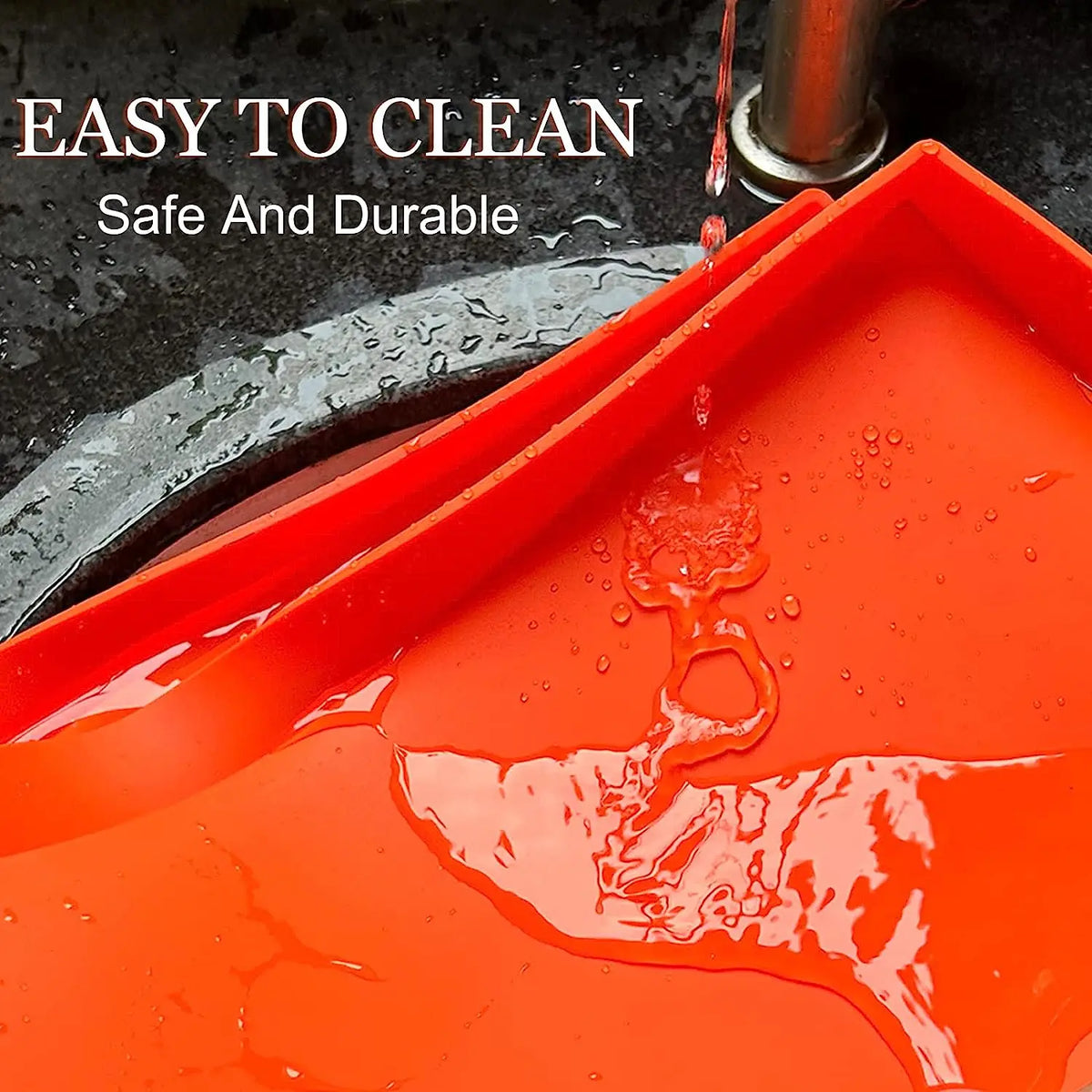 A bright orange silicone BBQ baking mat is shown being washed under a faucet.