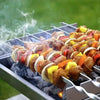 Durable stainless steel BBQ skewers being grilled over hot coals with smoke rising.
