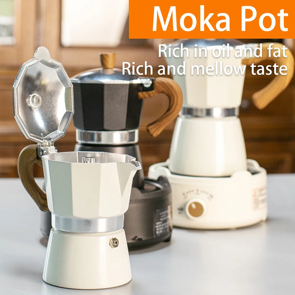 Ein Set klassischer Aluminium-Moka-Kannen in Schwarz und Weiß auf einer hellen Oberfläche.