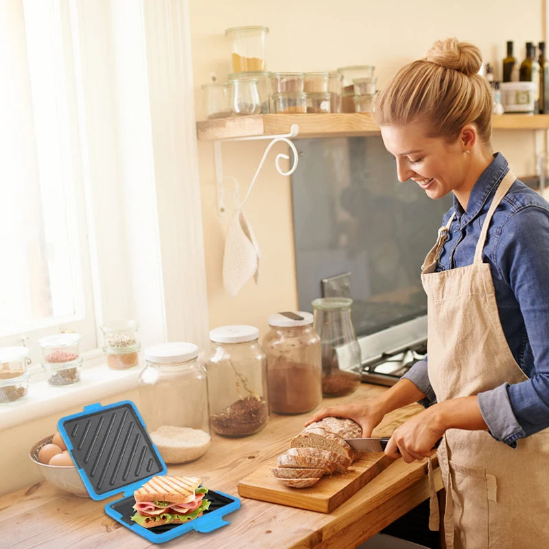 A woman prepares sandwiches using a food grade silicone microwave sandwich maker on a wooden cutting board.
