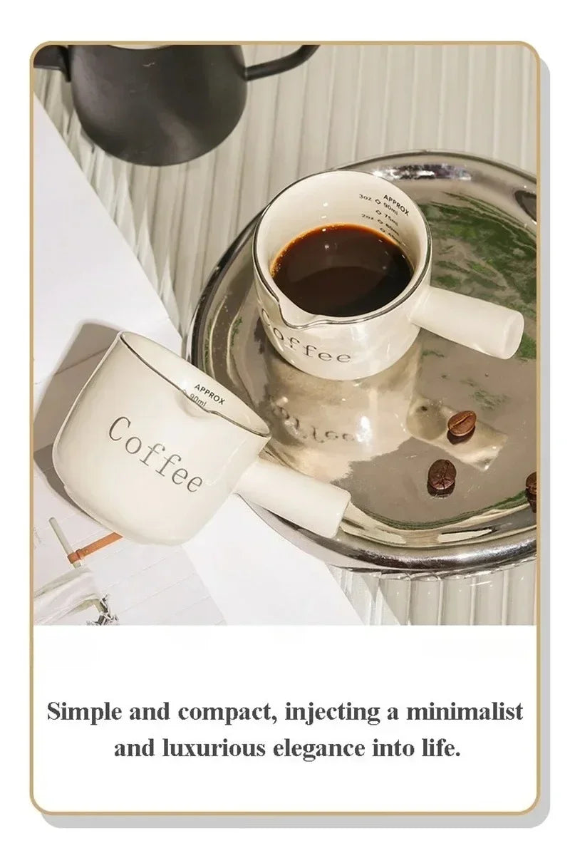 A white ceramic espresso coffee cup set with a dark liquid, resting on a silver tray.