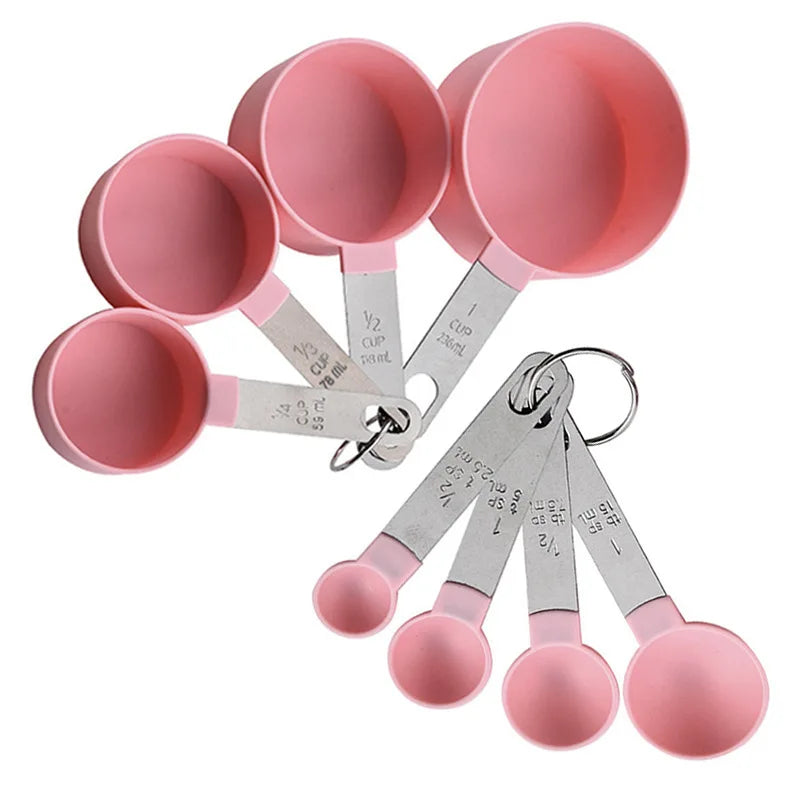 A set of pink precision stainless steel measuring spoons and cups.