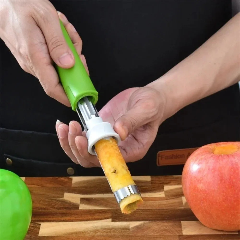 Une main utilise un éplucheur et un couteau vert et argenté pour retirer le cœur d'une pomme sur une planche à découper en bo