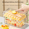 A hand is pressing a yellow release mechanism on an ice cube tray inside a clear storage box filled with colorful ice cubes.