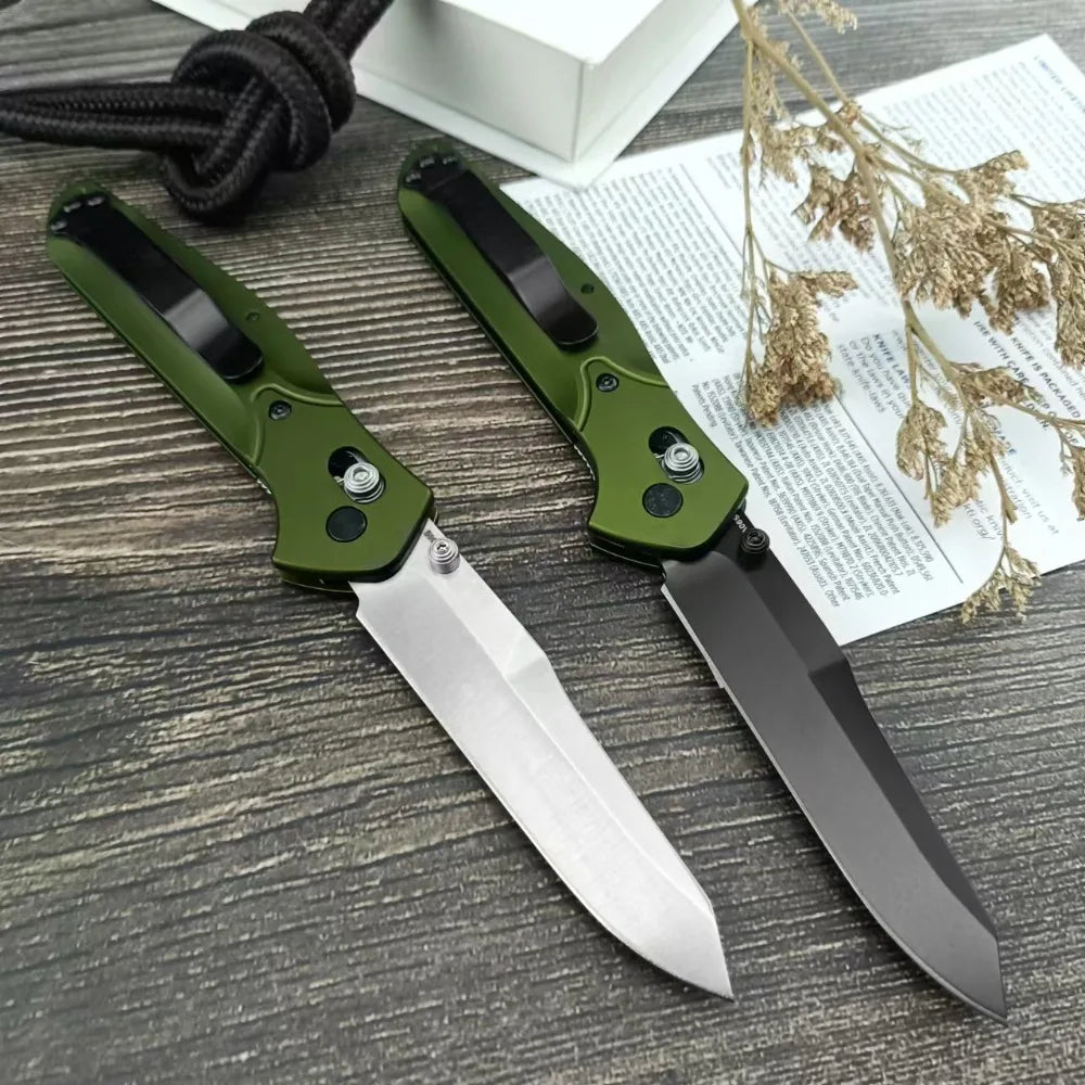 Taktisches faltbares Taschenmesser mit grünem Griff und silberner Klinge auf Holz neben getrocknetem Laub.