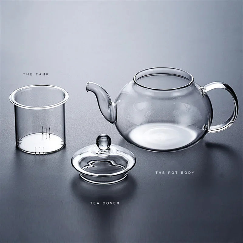 A clear glass tea set featuring a teapot, pot body, and tea cover arranged on a dark surface.