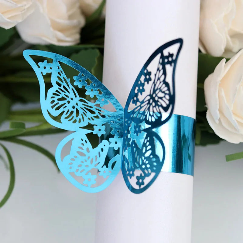 Blue laser cut butterfly napkin rings displayed on a white candle.